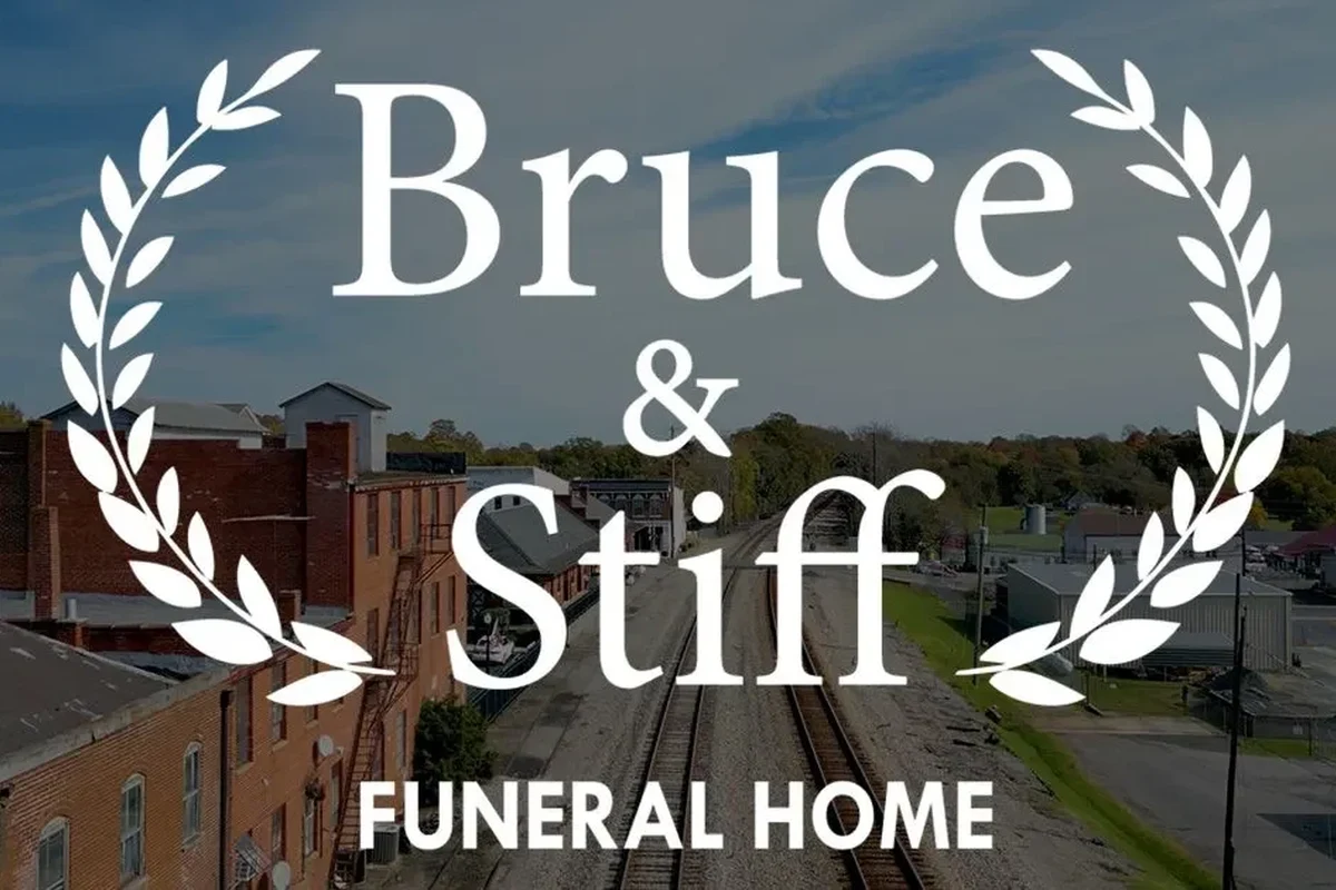 Funeral home obituary page on a laptop with service details and memorial information