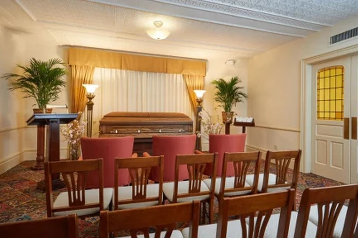 Funeral home obituary page on a laptop with a calm, simple layout