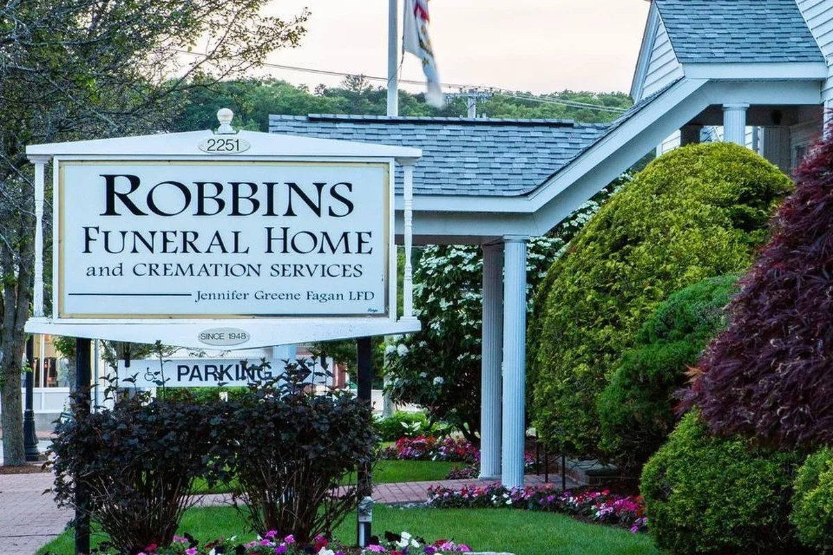 Funeral home obituary page on a laptop with service details and condolence notes
